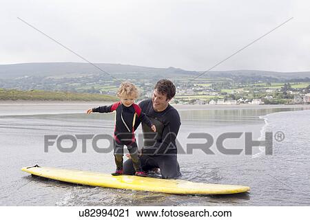 Father teaching son how to surf View Large Photo Image Stock Image - Father teaching son how to surf. Fotosearch