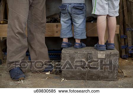 Father with sons standing on tool box in boat workshop View Large Photo Image Stock Photography - Father with sons standing on tool box in boat workshop. Fotosearch