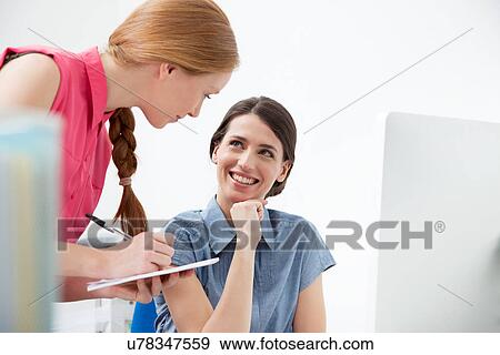 Female colleagues talking, one making notes View Large Photo Image Stock Photo - Female colleagues talking, one making notes. Fotosearch