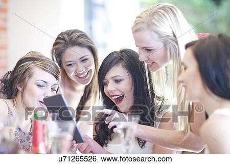 Female friends laughing at digital tablet View Large Photo Image Stock Photograph - Female friends laughing at digital tablet. Fotosearch