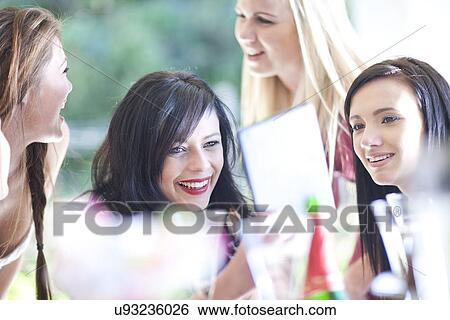 Female friends looking at digital tablet View Large Photo Image Stock Photograph - Female friends looking at digital tablet. Fotosearch