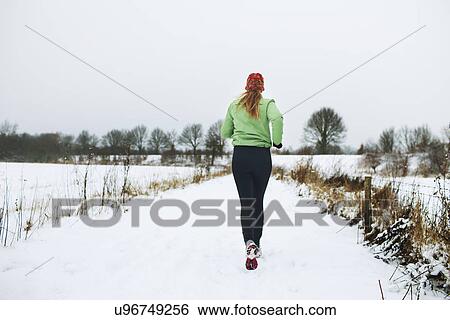 Female jogger running in snow View Large Photo Image Stock Photograph - Female jogger running in snow. Fotosearch