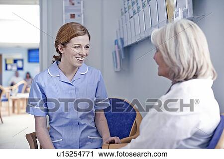 Female patient sitting with nurse in hospital waiting room View Large Photo Image Stock Image - Female patient sitting with nurse in hospital waiting room. Fotosearch