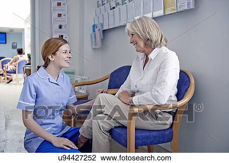 Female patient with nurse in hospital waiting room View Large Photo Image Stock Image - Female patient with nurse in hospital waiting room. Fotosearch