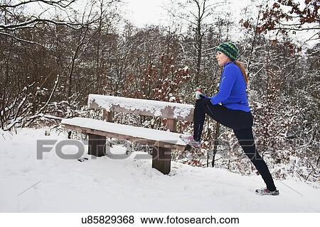 Female runner doing stretch exercises in snow View Large Photo Image Stock Photo - Female runner doing stretch exercises in snow. Fotosearch