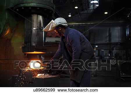 Stock Photo - Forge worker pre forms steel billet on 5 tonne clear space hammer before it will be presented to set of two dies to be fully forged in hammer. Fotosearch