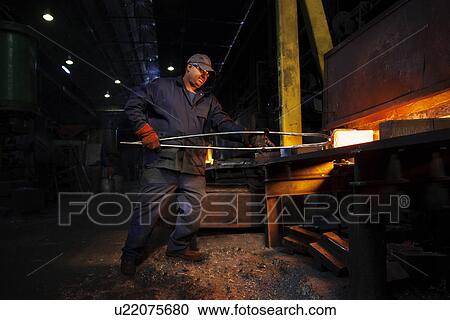 Forge worker removes red hot steel billet from furnace for forging into crank shaft View Large Photo Image Stock Image - Forge worker removes red hot steel billet from furnace for forging into crank shaft. Fotosearch