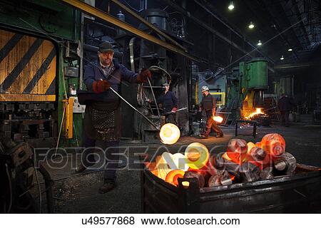 Forge worker swings finished forged component onto pallet as team works in background View Large Photo Image Stock Photo - Forge worker swings finished forged component onto pallet as team works in background. Fotosearch
