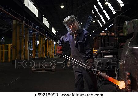 Forge worker with an upset forging of railway part View Large Photo Image Stock Image - Forge worker with an upset forging of railway part. Fotosearch