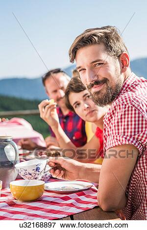 Friends enjoying breakfast outside, Tyrol, Austria View Large Photo Image Stock Photo - Friends enjoying breakfast outside, Tyrol, Austria. Fotosearch