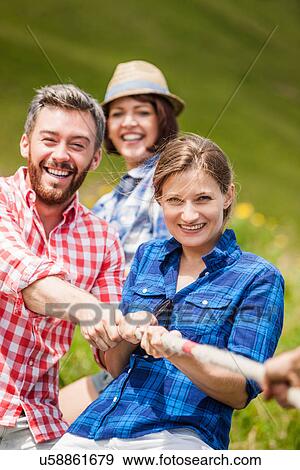 Stock Photo - Friends playing tug of war. Fotosearch