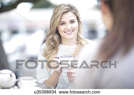 Picture - Friends sitting at outdoor cafe drinking coffee. Fotosearch