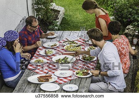 Friends sitting down to picnic lunch, Tyrol, Austria View Large Photo Image Stock Photo - Friends sitting down to picnic lunch, Tyrol, Austria. Fotosearch