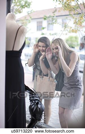 Friends window shopping, looking through shop front View Large Photo Image Stock Image - Friends window shopping, looking through shop front. Fotosearch