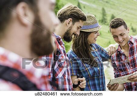 Stock Image - Friends with map, hiking. Fotosearch