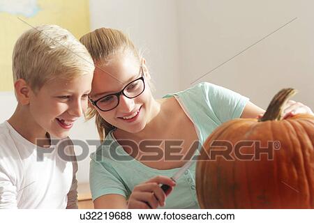 Girl and boy preparing to carve a pumpkin View Large Photo Image Stock Photo - Girl and boy preparing to carve a pumpkin. Fotosearch