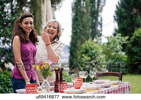 Girl and grandmother at table for family meal View Large Photo Image Stock Photo - Girl and grandmother at table for family meal. Fotosearch