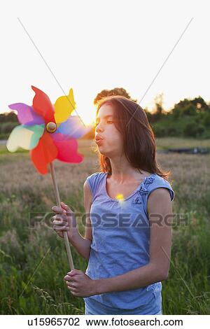 Girl blowing toy windmill View Large Photo Image Stock Image - Girl blowing toy windmill. Fotosearch