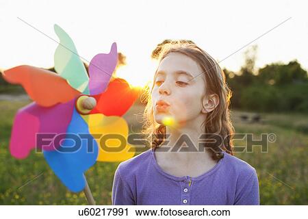 Girl blowing toy windmill View Large Photo Image Stock Image - Girl blowing toy windmill. Fotosearch
