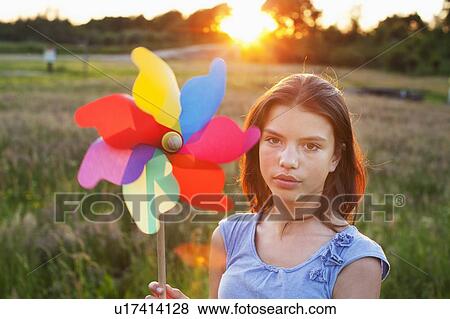 Girl holding toy windmill View Large Photo Image Stock Photo - Girl holding toy windmill. Fotosearch