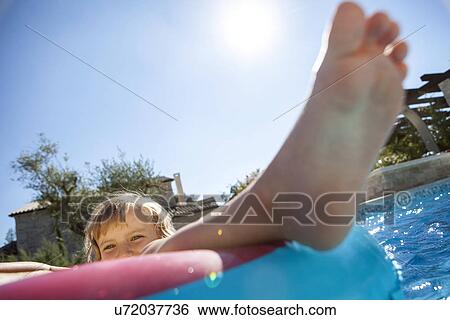 Stock Photograph - Girl in inflatable ring in pool. Fotosearch
