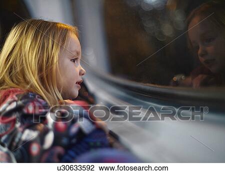 Girl looking out of a bus window during a journey at night View Large Photo Image Stock Image - Girl looking out of a bus window during a journey at night. Fotosearch