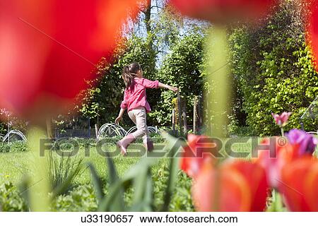 Girl playing in garden View Large Photo Image Stock Photo - Girl playing in garden. Fotosearch
