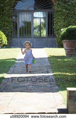 Girl running through garden carrying bucket View Large Photo Image Picture - Girl running through garden carrying bucket. Fotosearch