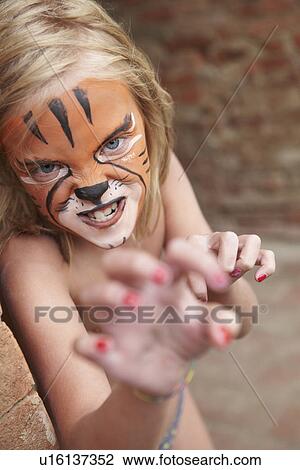Girl with face painting imitating tiger View Large Photo Image Stock Image - Girl with face painting imitating tiger. Fotosearch