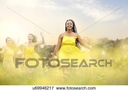 Girls in yellow dancing on meadow View Large Photo Image Stock Photo - Girls in yellow dancing on meadow. Fotosearch