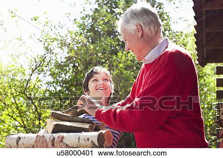 Grandfather and grandson with logs View Large Photo Image Stock Image - Grandfather and grandson with logs. Fotosearch