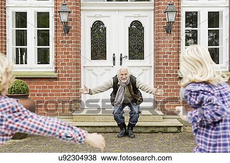 Grandfather welcoming grandchildren with arms open View Large Photo Image Stock Photo - Grandfather welcoming grandchildren with arms open. Fotosearch