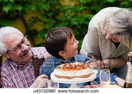 Grandparents surprising grandson with birthday cake View Large Photo Image Stock Image - Grandparents surprising grandson with birthday cake. Fotosearch