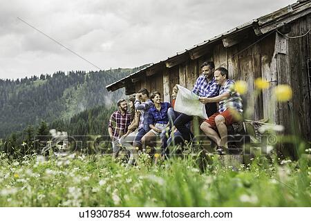 Group of friends chatting and reading map, Tirol, Austria View Large Photo Image Picture - Group of friends chatting and reading map, Tirol, Austria. Fotosearch