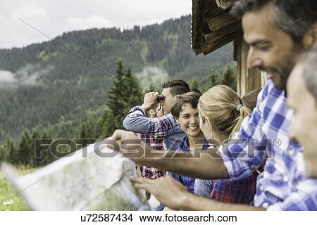 Picture - Group of friends chatting and reading map, Tirol, Austria. Fotosearch