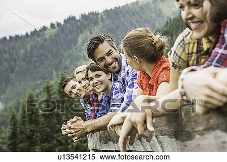 Group of friends leaning on wooden fence, Tirol, Austria View Large Photo Image Stock Photography - Group of friends leaning on wooden fence, Tirol, Austria. Fotosearch