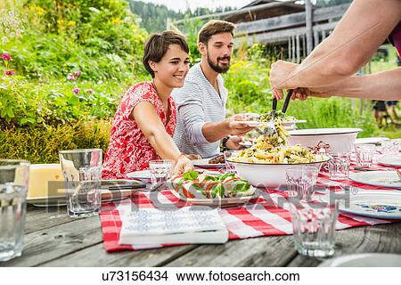 Group of friends sharing picnic lunch, Tyrol, Austria View Large Photo Image Picture - Group of friends sharing picnic lunch, Tyrol, Austria. Fotosearch