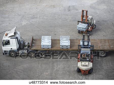 High angle view of fork lift trucks loading alloy ingots onto transport View Large Photo Image Picture - High angle view of fork lift trucks loading alloy ingots onto transport. Fotosearch