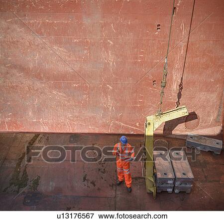 High angle view of worker checking metal alloy ingots in ship's hold View Large Photo Image Stock Photo - High angle view of worker checking metal alloy ingots in ship's hold. Fotosearch