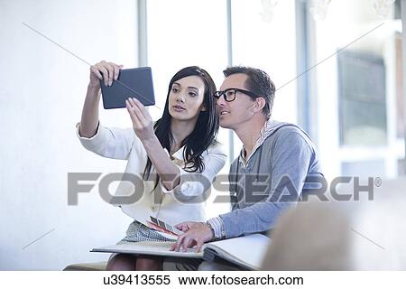 Interior designer and client looking at digital tablet View Large Photo Image Stock Photography - Interior designer and client looking at digital tablet. Fotosearch