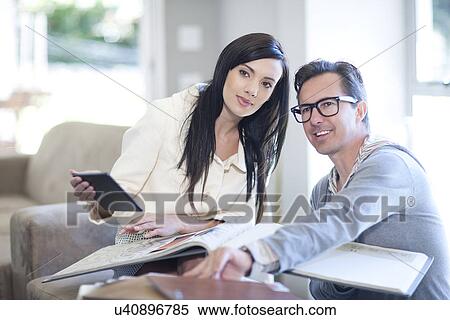 Stock Photography - Interior designer and client looking at design books. Fotosearch