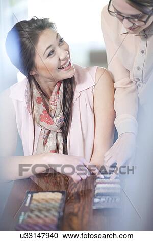 Stock Image - Interior designer and client with textile swatches. Fotosearch