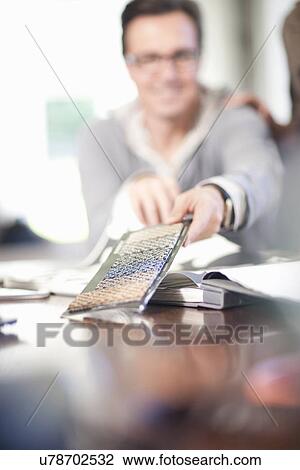 Stock Image - Interior designer looking at textile swatches. Fotosearch
