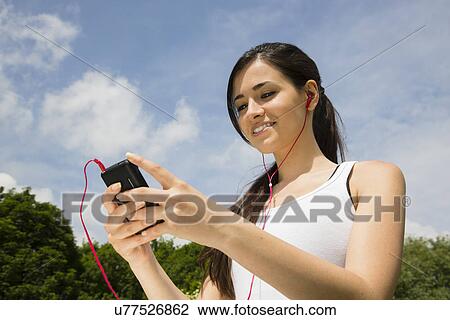 Jogger listening to mp3 player with earphones View Large Photo Image Stock Image - Jogger listening to mp3 player with earphones. Fotosearch