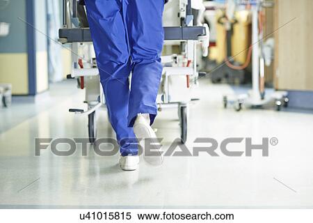 Stock Photography - Legs of medic running with gurney along hospital corridor. Fotosearch