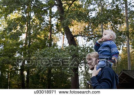 Little boy on father's shoulders View Large Photo Image Stock Image - Little boy on father's shoulders. Fotosearch