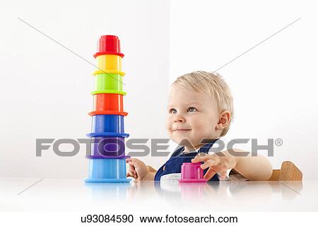 Stock Image - Little boy playing with stacking cups. Fotosearch