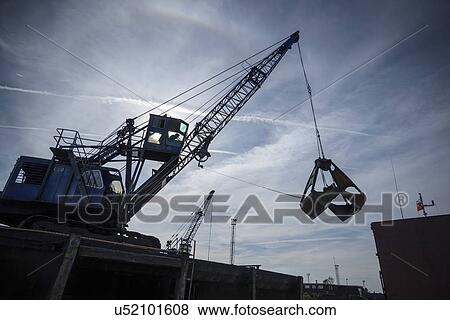 Low angle view of crane in silhouette in port View Large Photo Image Stock Photo - Low angle view of crane in silhouette in port. Fotosearch