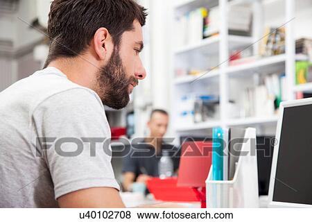 Male colleagues working in office View Large Photo Image Stock Photo - Male colleagues working in office. Fotosearch
