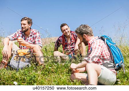 Male friends resting on hike, Tyrol, Austria View Large Photo Image Stock Image - Male friends resting on hike, Tyrol, Austria. Fotosearch